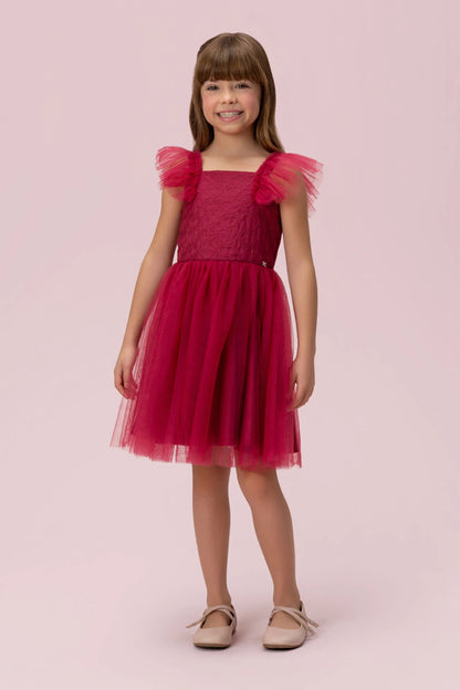 Menina com vestido infantil vermelho Petit Cherie, mangas volumosas em tule e saia franzida.