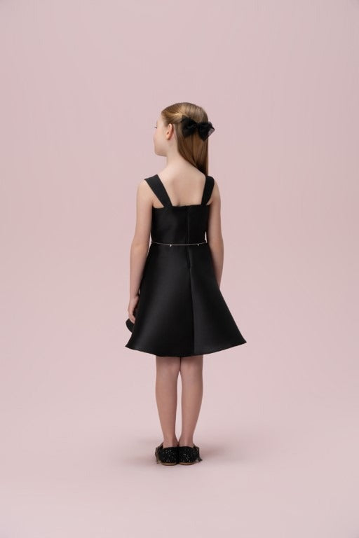  Vestido infantil preto liso Petit Cherie visto de costas, com alças largas, cintura marcada e saia evasê.