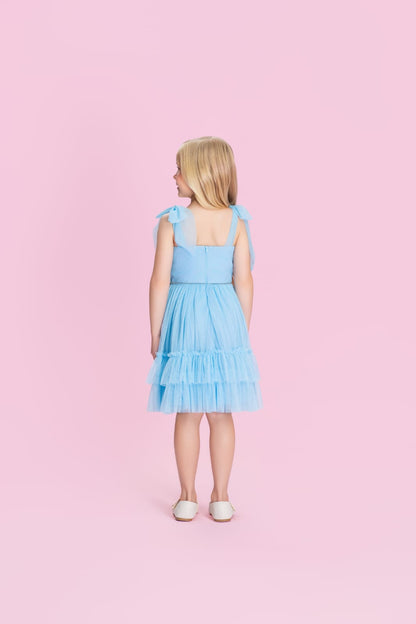 Menina de costas com vestido infantil azul em tule e fechamento em ziper