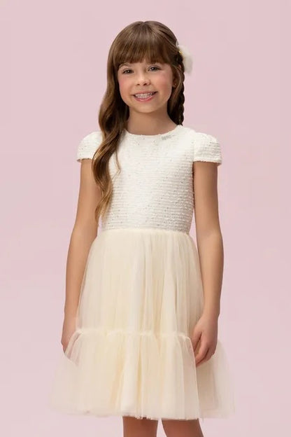 Detalhes do vestido creme Petit Cherie com decote arredondado, mangas curtas e saia em tule.